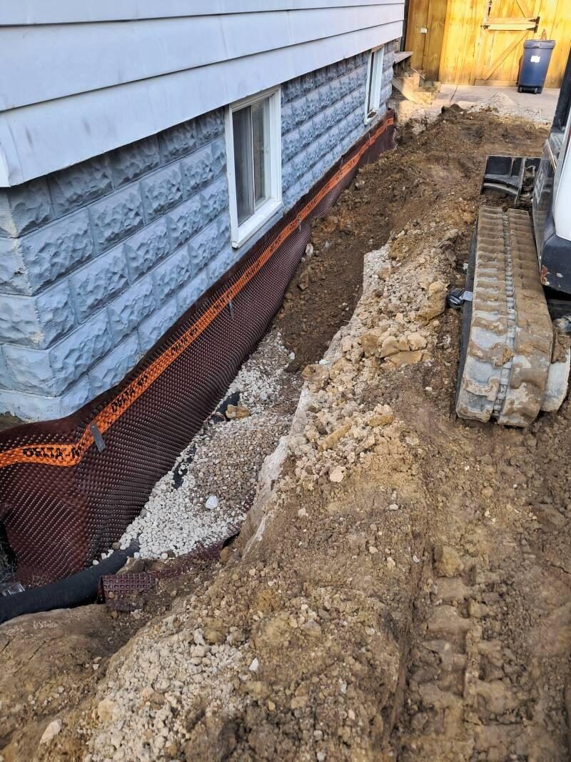 Exterior drain tile system with dimple-board membrane and drainage stone along a foundation, by OARA